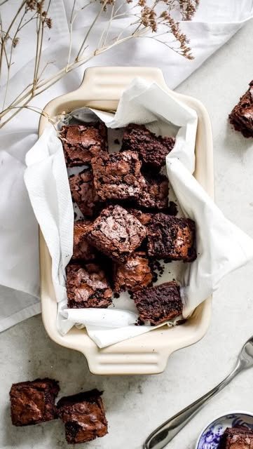 Brownie squares stacked in a baking dish